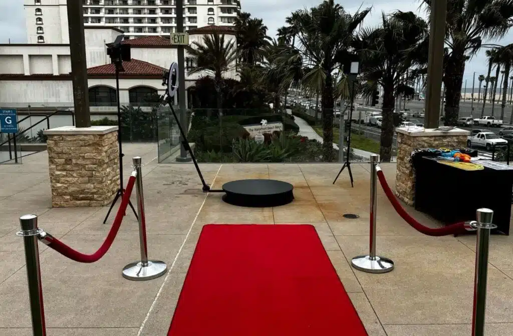 360 photo booth setup placed outdoors with red carpet and stanchions, ready for event.