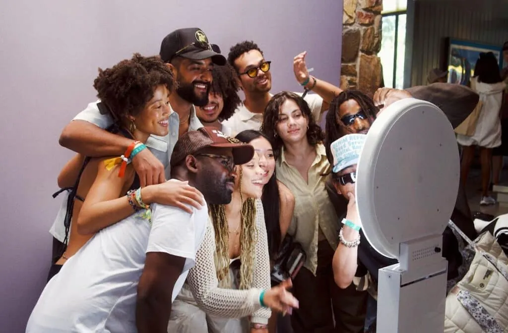 Smiling group of friends using a photo booth with fun accessories