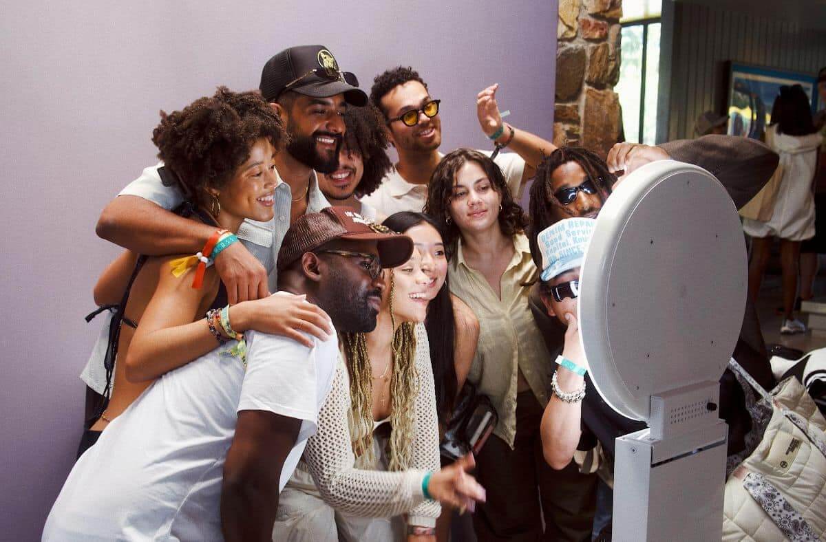 Smiling group of friends using a photo booth with fun accessories