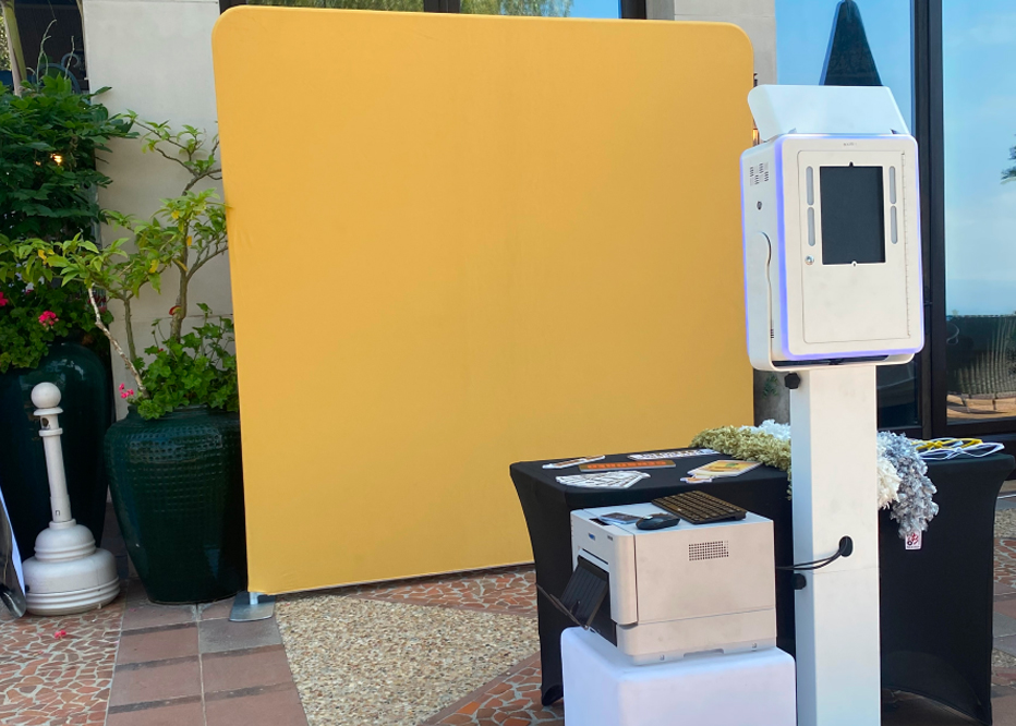 Our Classic Photo Booth Rental setup with a sleek white design, printer, and props table for events.