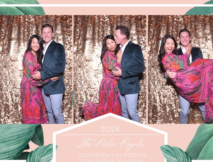 A couple poses playfully at The Palm Royale 2024 corporate photo booth with a gold sequin backdrop.