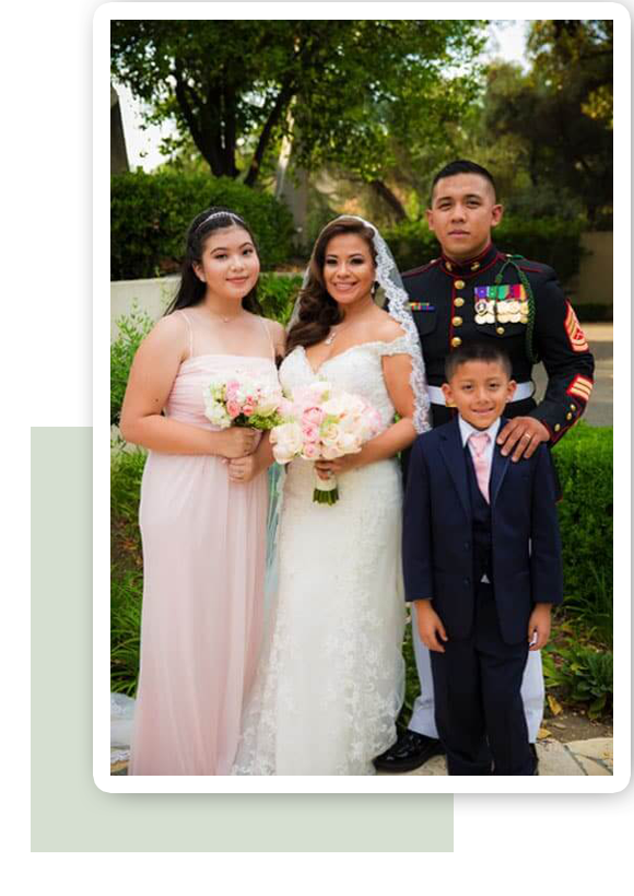 Smiling family in formal wear posing for a wedding portrait.