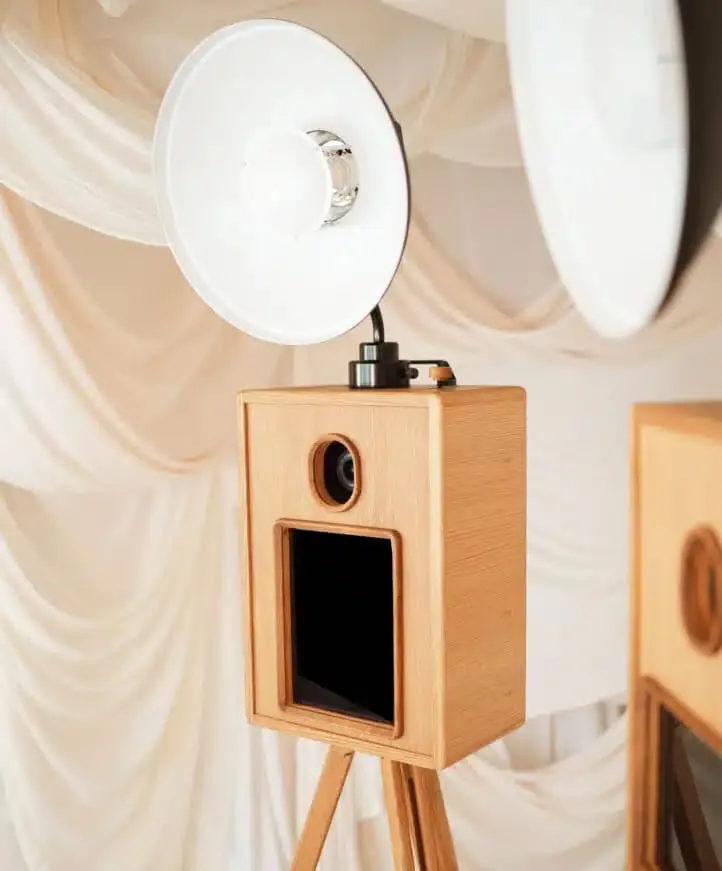 Glam photo booth with wood finish and soft drape backdrop for stylish, celeb-style event portraits.