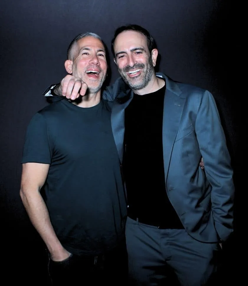 Two buddies laughing with black backdrop at AC's 50th birthday photo booth in Corona