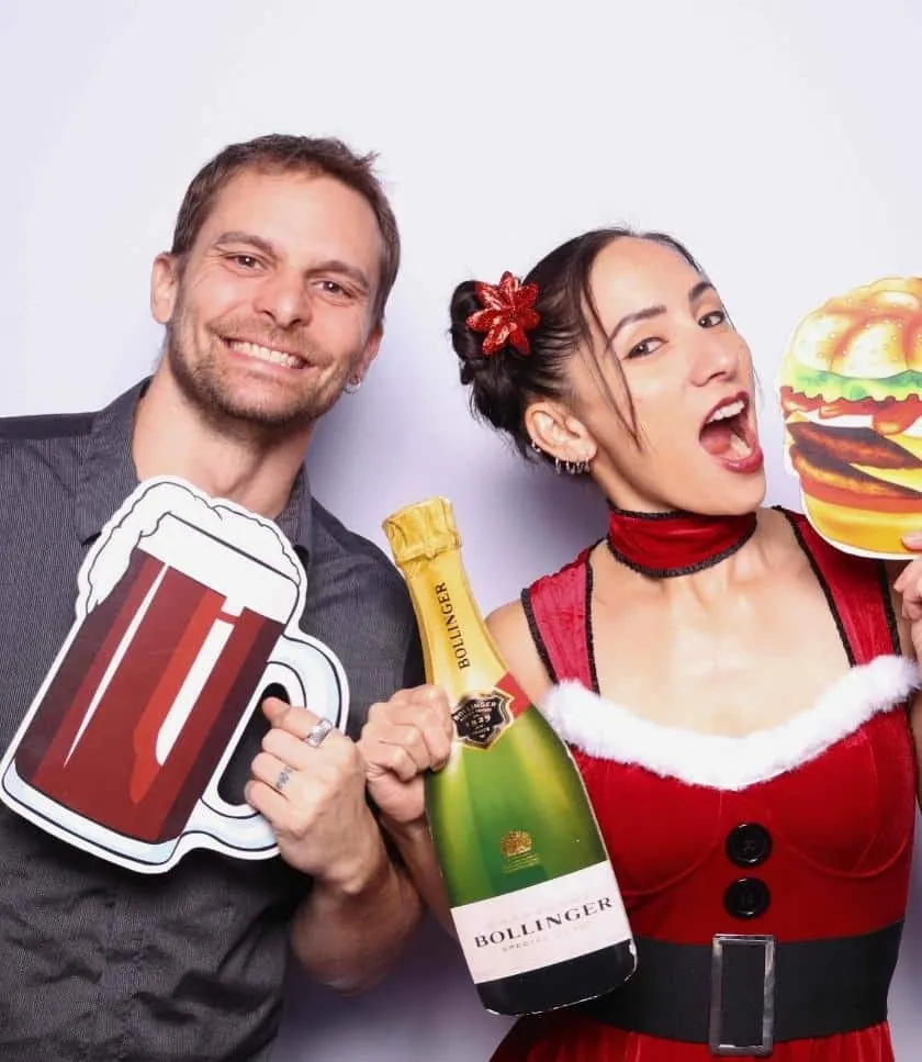 Two colleagues posing with festive props at the Sasooness Law Group 2024 Holiday Party photo booth.