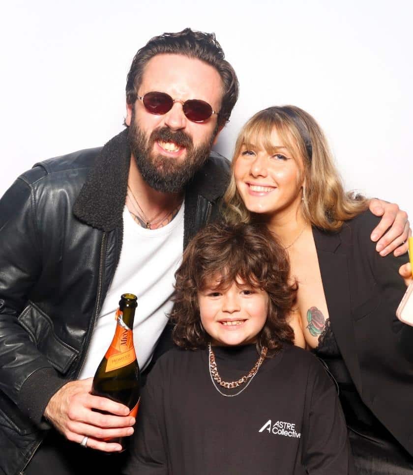 Smiling family with drink posing at Astre Collective company photo booth rental in Riverside.