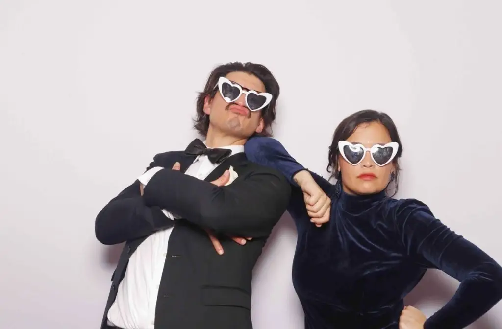 A couple wearing sunglasses pose for a photo