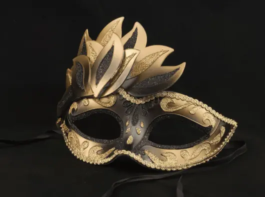 a black and gold masquerade mask on a black background