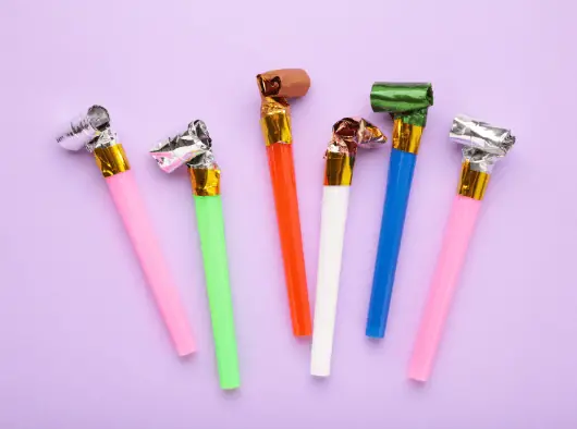 a group of colorful party blowers on a purple background