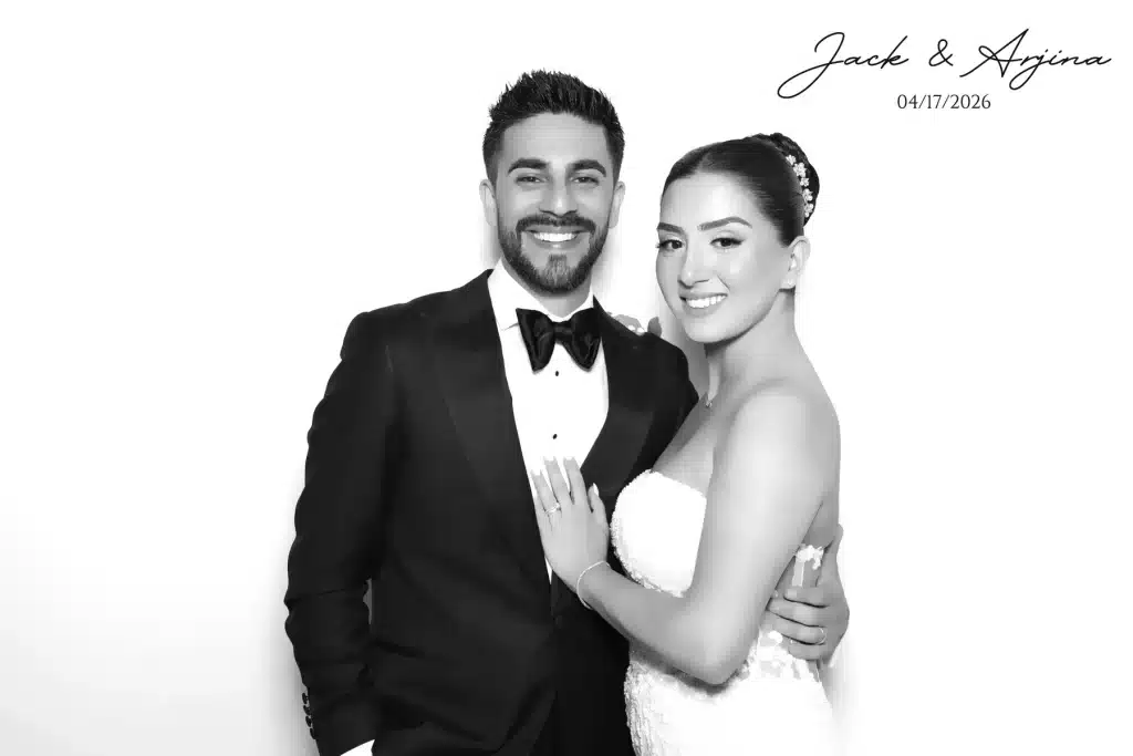 Jack and Arjina posing in a black-and-white Glam Booth wedding portrait.
