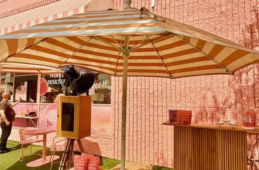 Wooden Glam Photo Booth setup for Whata Peach x Blume brand activation outside a pink storefront.