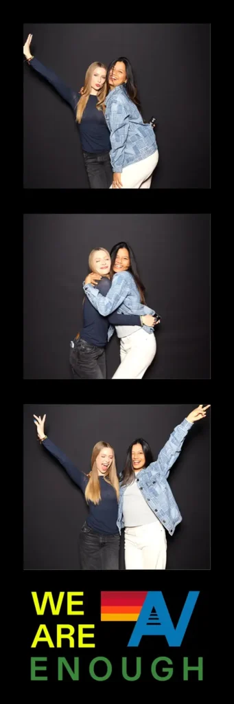Two women hug, laugh, and raise their arms in playful poses across a three-photo booth strip.