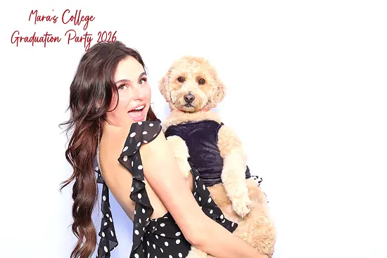 Woman holds her dog in her arms for a cute pet photo booth pose.