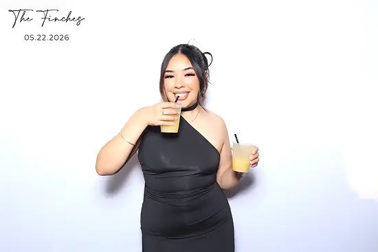 Woman smiles while sipping a drink and holding another cup