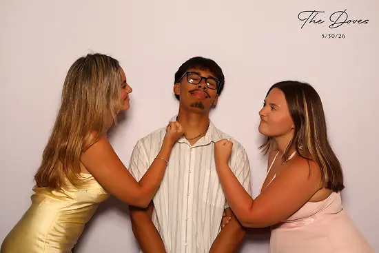 Two women playfully trying to punch the guy while he poses dramatically