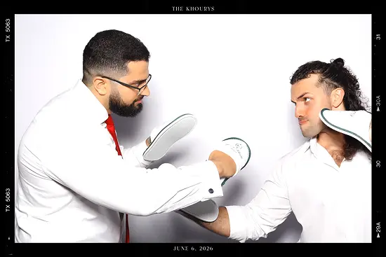 Two men face off while playfully holding slippers like boxing gloves