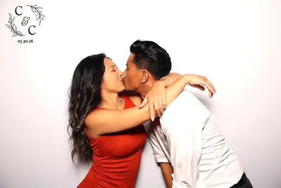 Couple embraces and kisses while leaning toward each other
